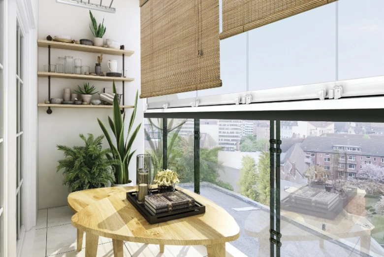 Moderní balkon s velkým zasklením, dřevěným stolem a rostlinami.