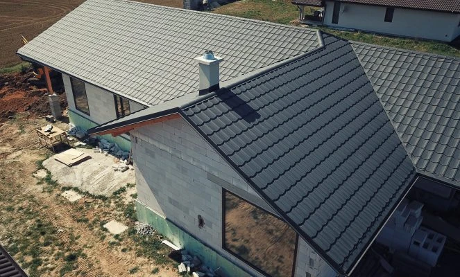 Střecha domu v stavbě s šedými taškami.