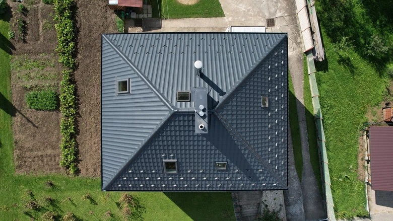 Zdokonalená montáž plechové střechy na rodinném domě z výšky.