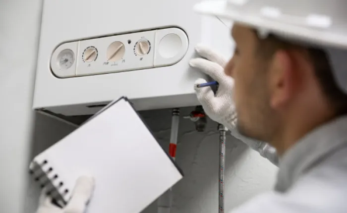 Technik kontroluje topení pro úsporu energie v domácnosti.