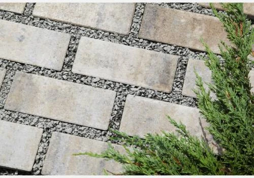 Prostupná betonová dlažba s kamenivem mezi kostky a zelení