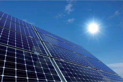 Fotografie modrých fotovoltaických panelů na střeše pod sluncem.