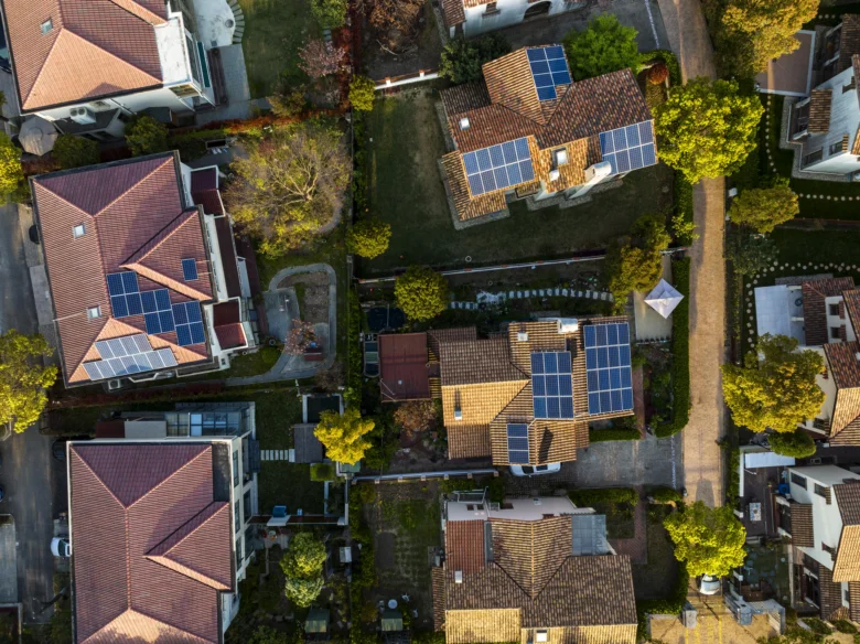 Vzdušný pohled na rodinné domy s fotovoltaickými panely.