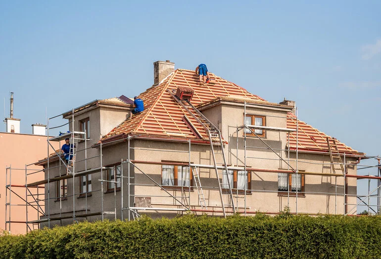 Práce na rekonstrukci střechy domu s lešení.