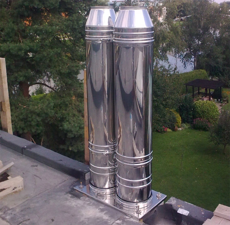 Dva nerezové komínové ventilátory na střeše.