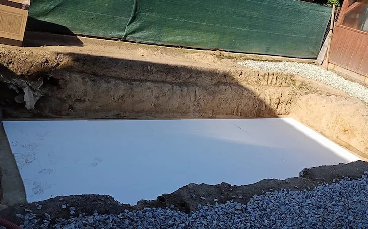 Bílý extrudovaný polystyren položený na dno vykopaného bazénu.