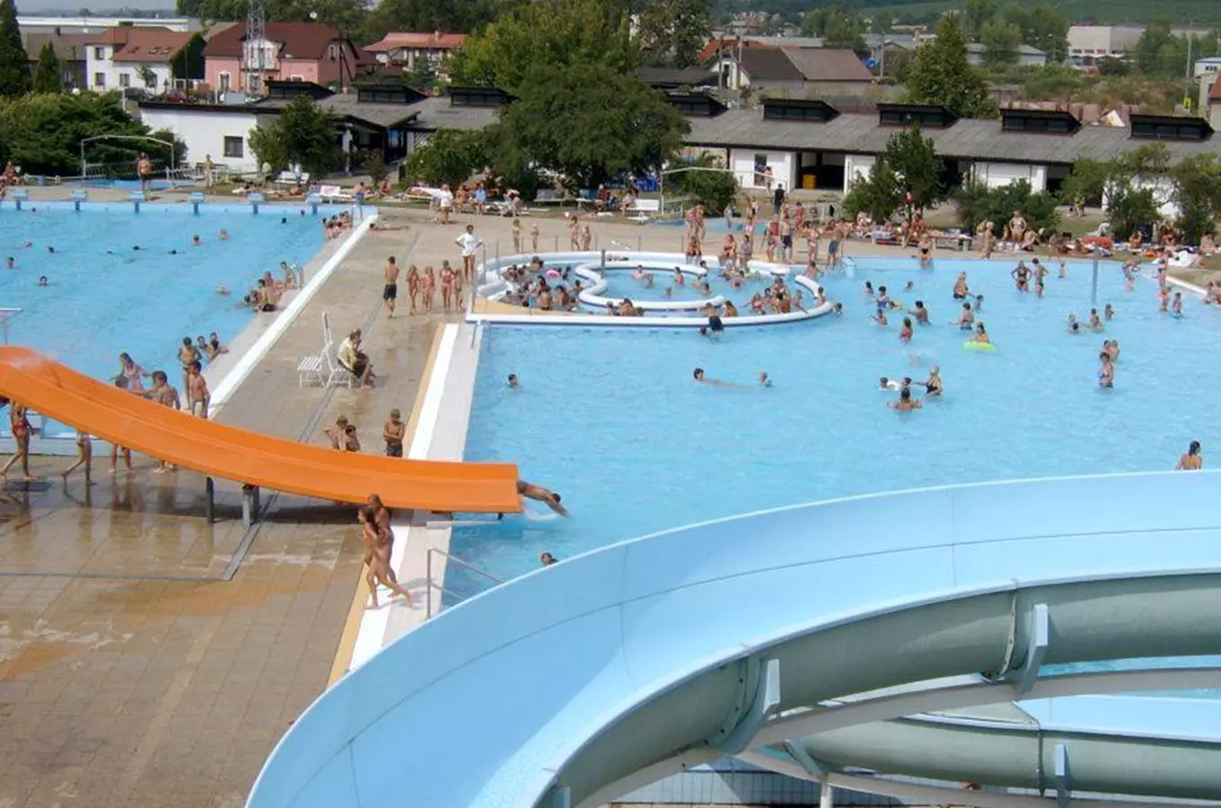 Venkovní bazén s vodními skluzavkami v Mělníku plný lidí