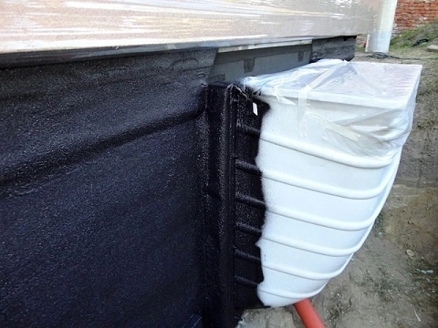 Detailní pohled na hydroizolaci základové desky s černou fólií.