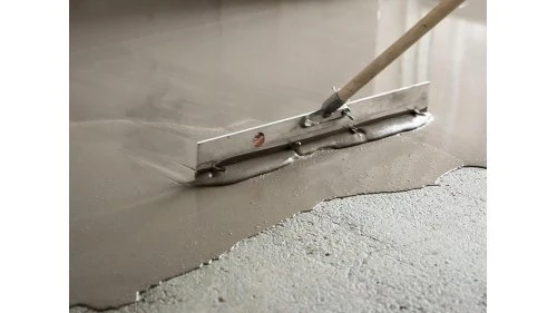 Nástroj na rozprostírání samonivelační stěrky na podlaze.