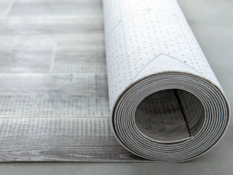 Svinutý lino podlahový materiál s dřevotiskem na neutrálním pozadí.