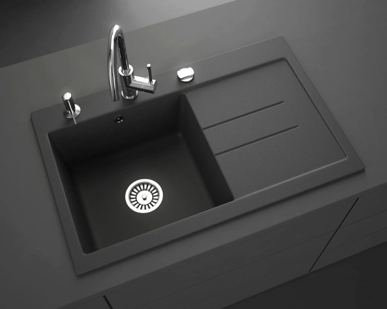Moderní kuchyňský drez z granitu s odkapávacím povrchem.
