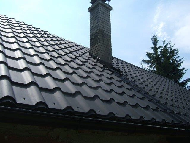 Plechová střešní krytina s komínem na skloněné střechy