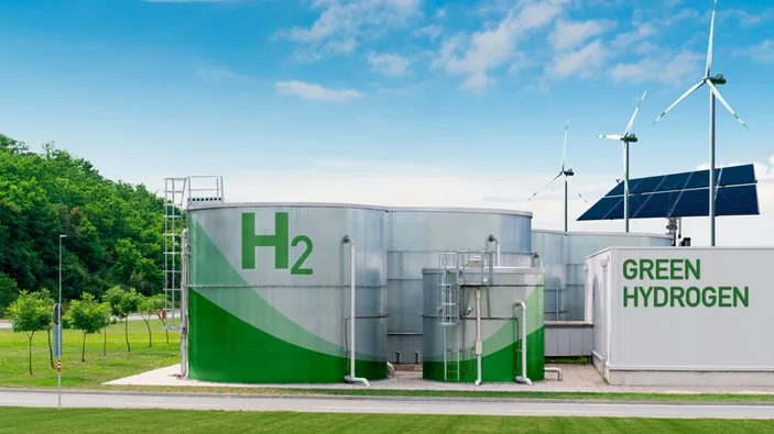 Zelená vodíková elektrárna s větrnými turbínami a solárními panely.