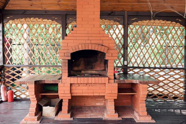 Venkovní gril z cihel s kamny v dřevěné pergole
