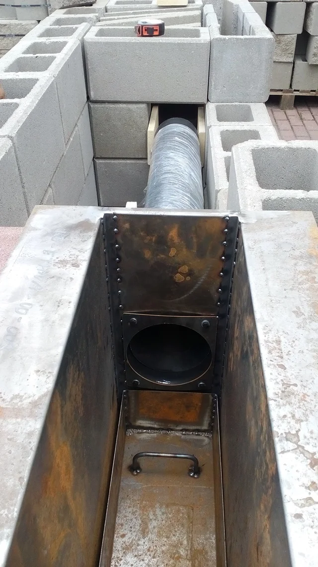 Krok stavby zahradní udírny s kovovým krámem v betonu.