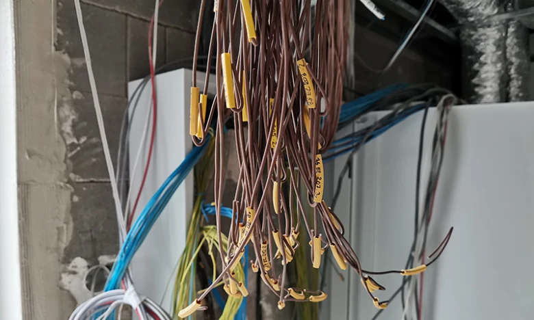 Instalace přívodního kabelu do domu s označenými vodiči.