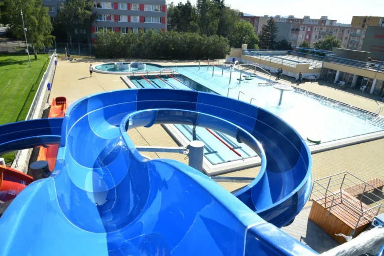 Modrá vodní skluzavka nad bazénem v koupališti.