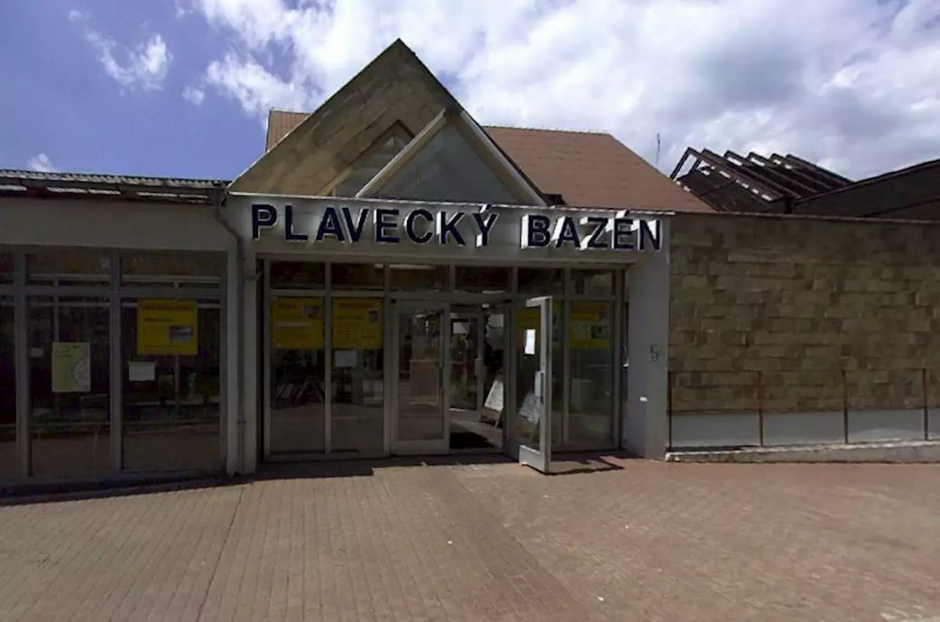 Vstup do plaveckého bazénu v Litoměřicích s nápisem na fasádě.