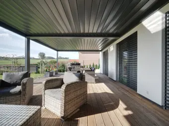Bioklimatická pergola s venkovním posezením na dřevěné terase.