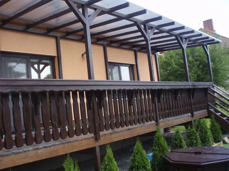 Dřevěný balkon s konstrukcí střechy na domě.
