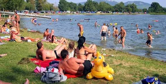 Lidé se koupají v přírodním jezeře na jižní Moravě.