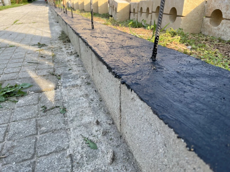 Tekutá hydroizolace se nanáší na betonovou zdi s výztuží.