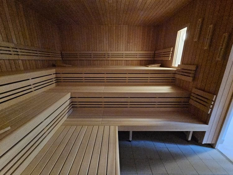 Sauna s dřevěnými lavicemi v bazénu nebo aquaparku.