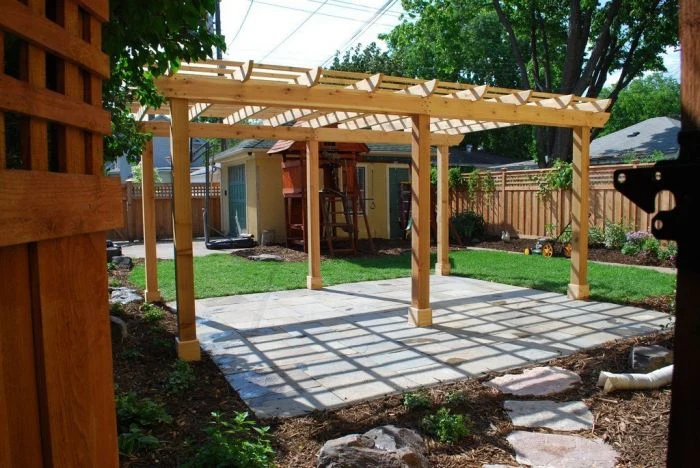 Dřevěná pergola postavená vlastními rukama na zahradním pozemku.
