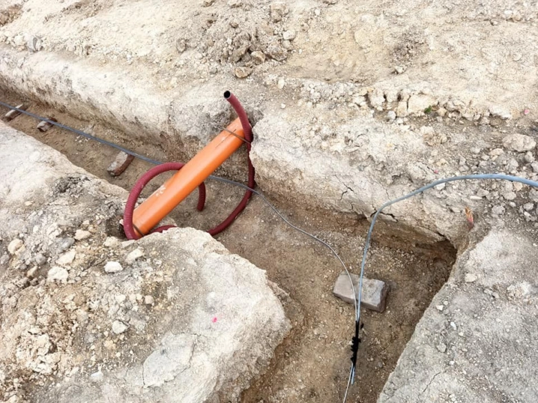 Instalace zemnícího pásku v zemi s kabely a vodičem.