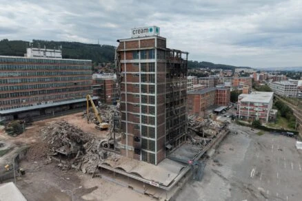 Stavební areál s demolovanou budovou v městském prostředí.