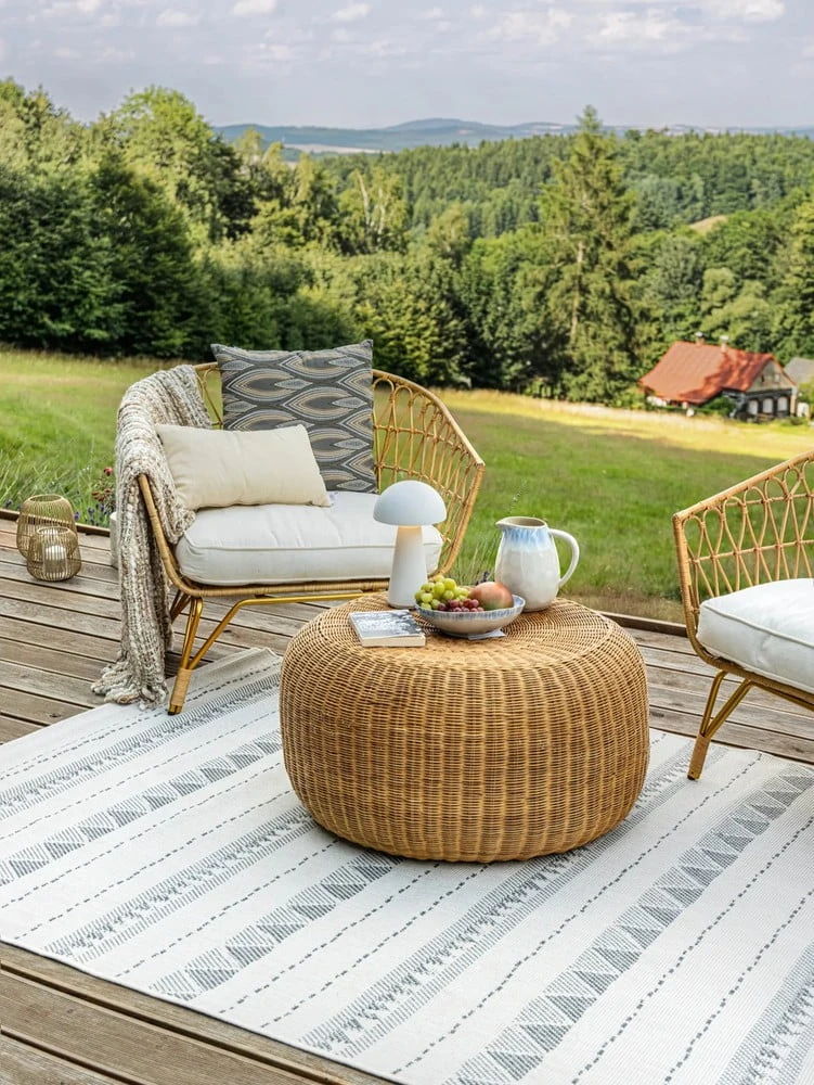 Užitečné balkónové posezení s ratanovou židlí a výhledem do přírody.