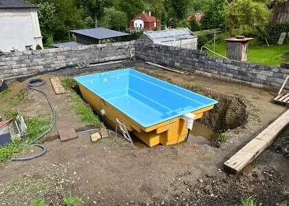 Modrý bazén v kamenné zdi během instalace.