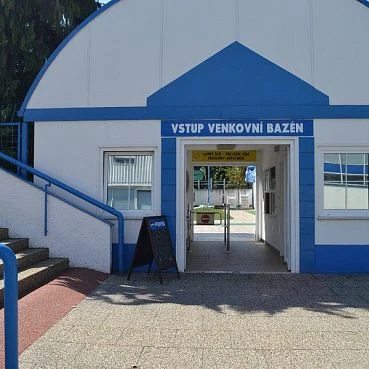 Vstup do venkovního bazénu v Novém Jičíne s modrým nápisem.
