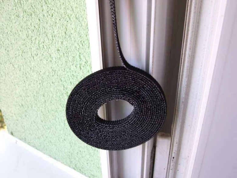 Černá síť proti hmyzu na okně v roli.