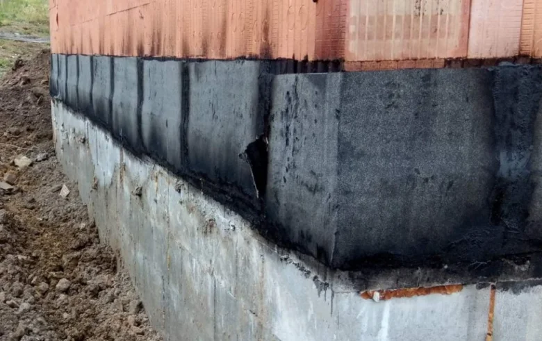 Detail zpětného spoje hydroizolace na rohu základové stěny.