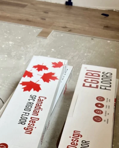 Krábice s podlahovými deskami na betonu před pokládkou.