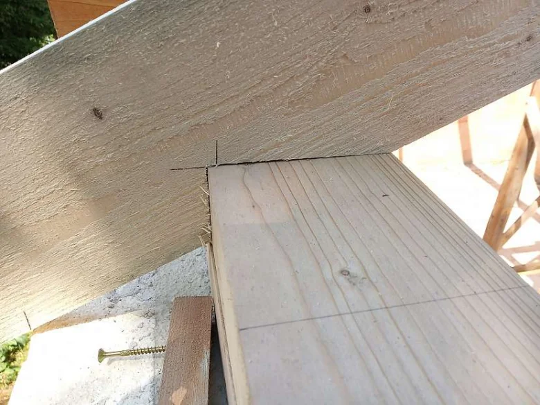 Příprava řezu sedla krokve na dřevěném nosníku s kreslenými značkami.