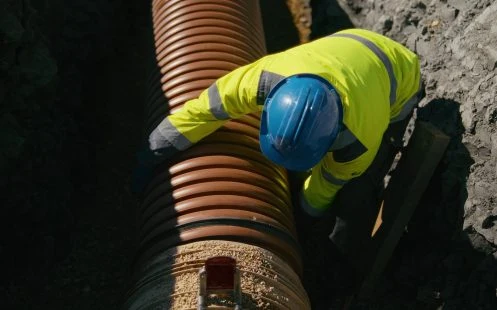 Montáž velkého drenážního potrubí na stavebním místě.
