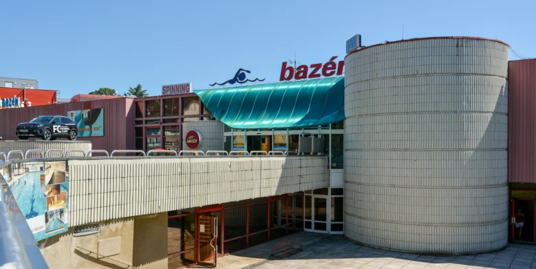 Vnější pohled na plavecký bazén v Liberci s cylindrickou budovou.