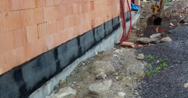 Detail zpětného spoje hydroizolace na základové stěně před zdivem.