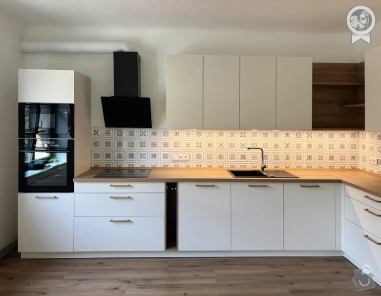 Moderní bílá kuchyň na míru s dřevěnými pracovními deskami.