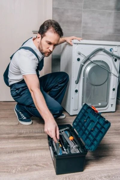 Technik opravuje pračku s nářadím v Brně