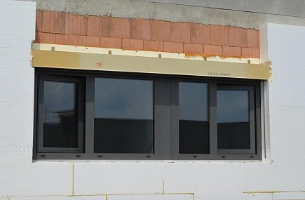 Instalace venkovní žaluzie s montážním rámem nad oknem.