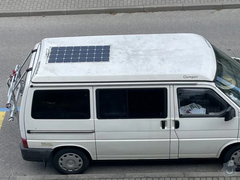 Bílá dodávka s fotovoltaickými panely na střeji pro mobilní energii.