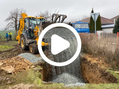 Zaplavování příkopu štěrkem při instalaci podzemní nádrže na dešťovou vodu.