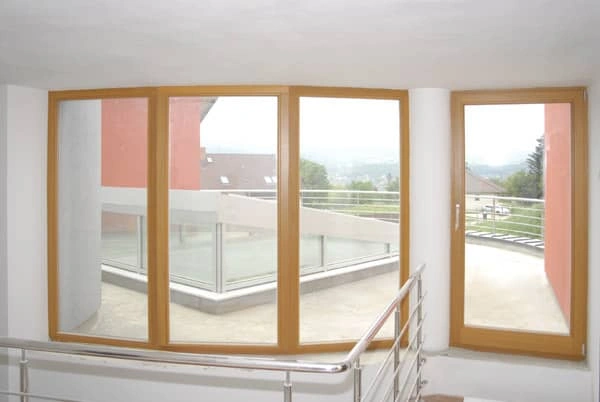 Velká dřevěná okna na balkóně s výhledem do okolí.