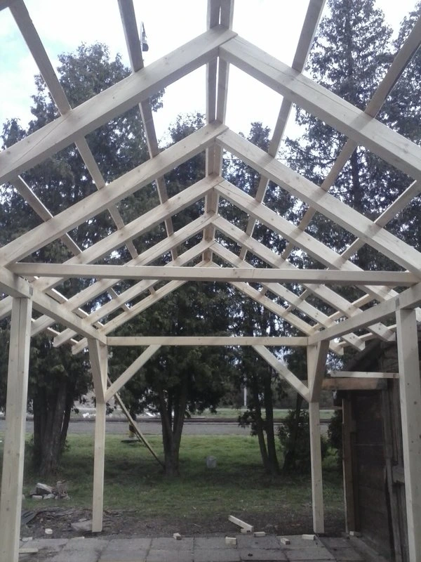 Dřevěná konstrukce střechy s viditelnými tesanými spoji trámů.