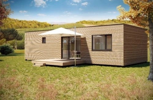 Moderní dřevostavba v podobě bungalovu na trávníku.