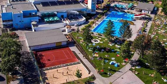 Pohled na aquapark s bazénymi a tenisovými dvory ve Zlínském kraji.