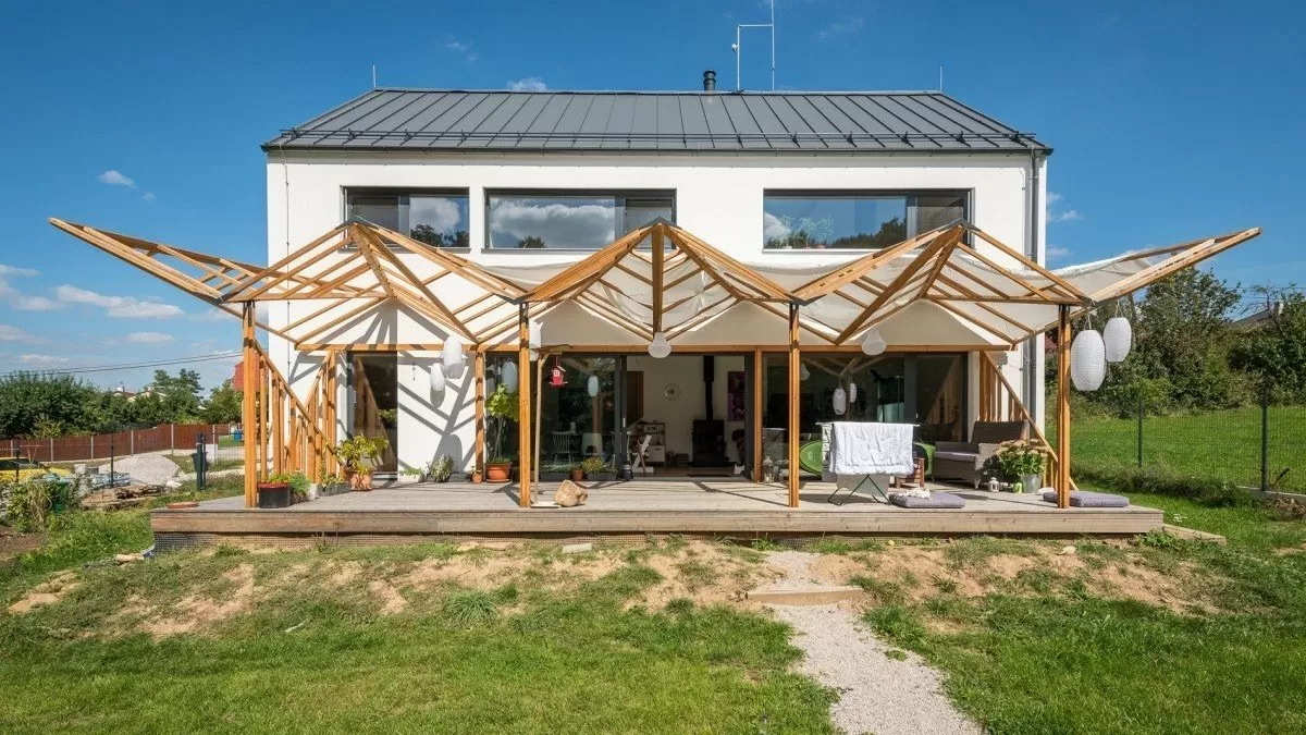 Dřevěná konstrukce s tesanými spoji na fasádě domu.